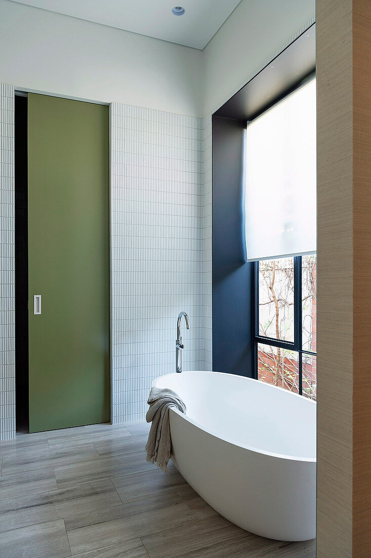 Minimalist bathroom with modern freestanding bathtub and color accents