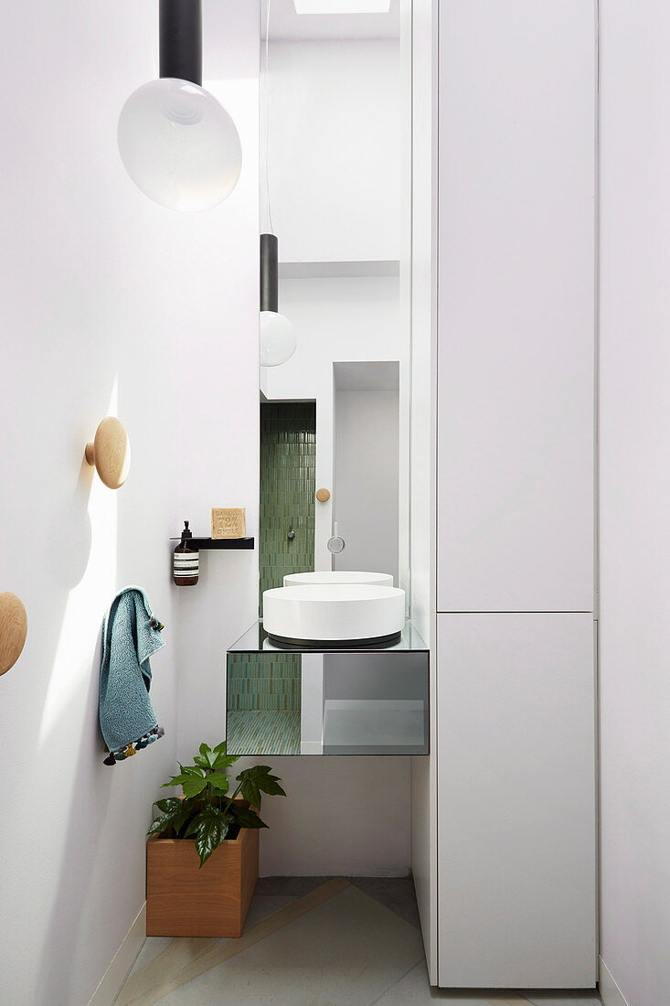 Modernes rundes Waschbecken auf verspiegeltem Hängetisch in Badezimmernische