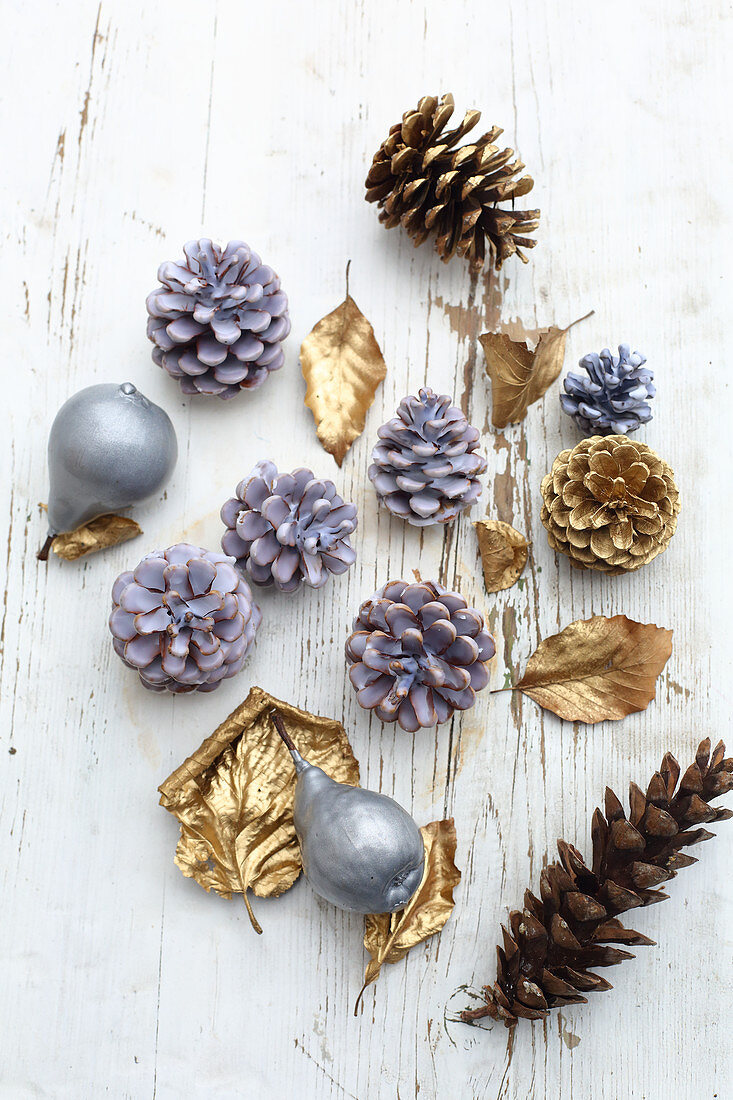 Fruits, pine cones and leaves dipped in coloured wax or sprayed gold