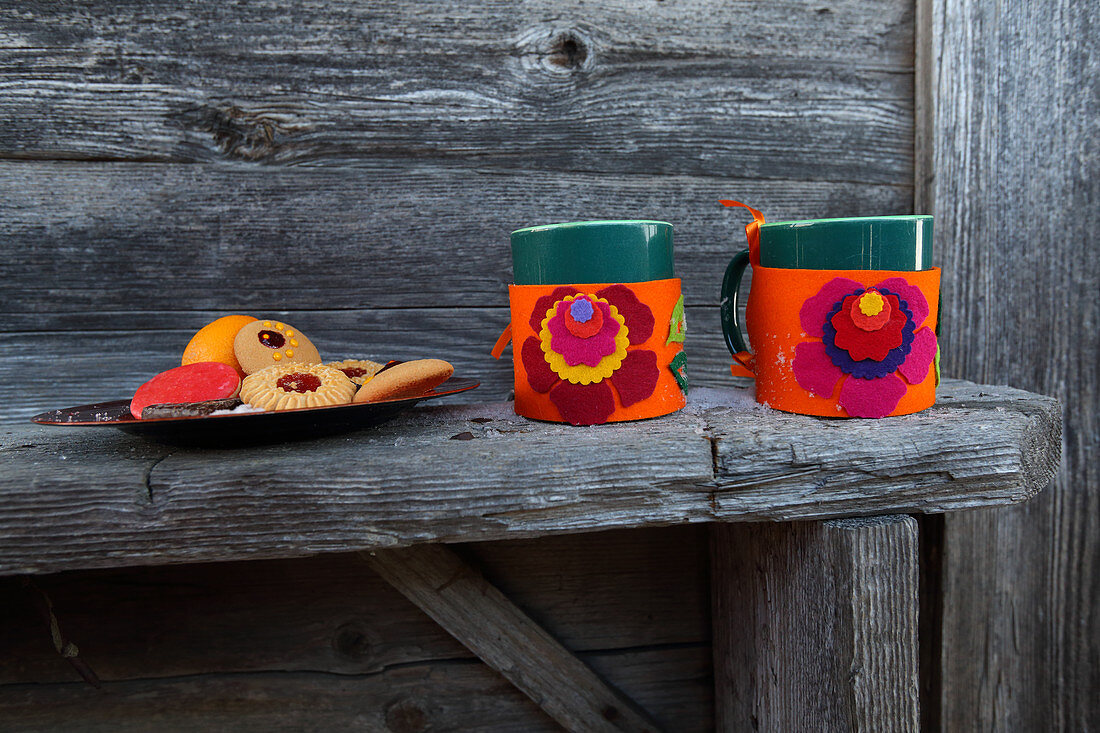Handmade felt mug cosies with colourful floral mtifs