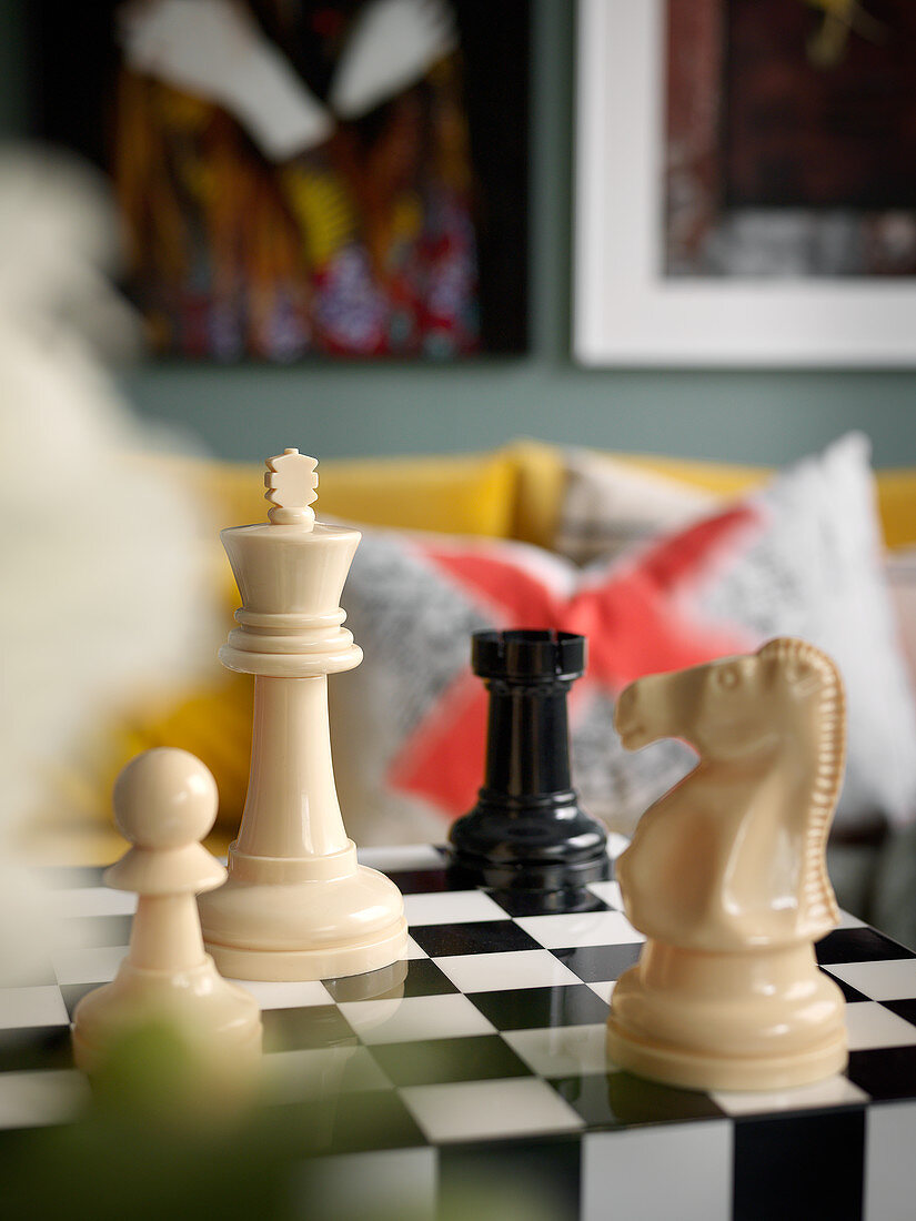 Schachbrettfiguren auf Tisch mit Schachbrettmuster