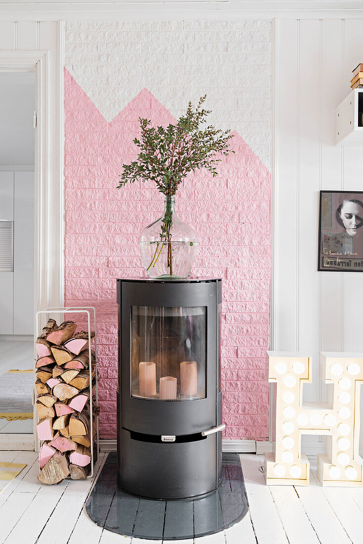 Attractive wood-burning stove against pink-and-white wall