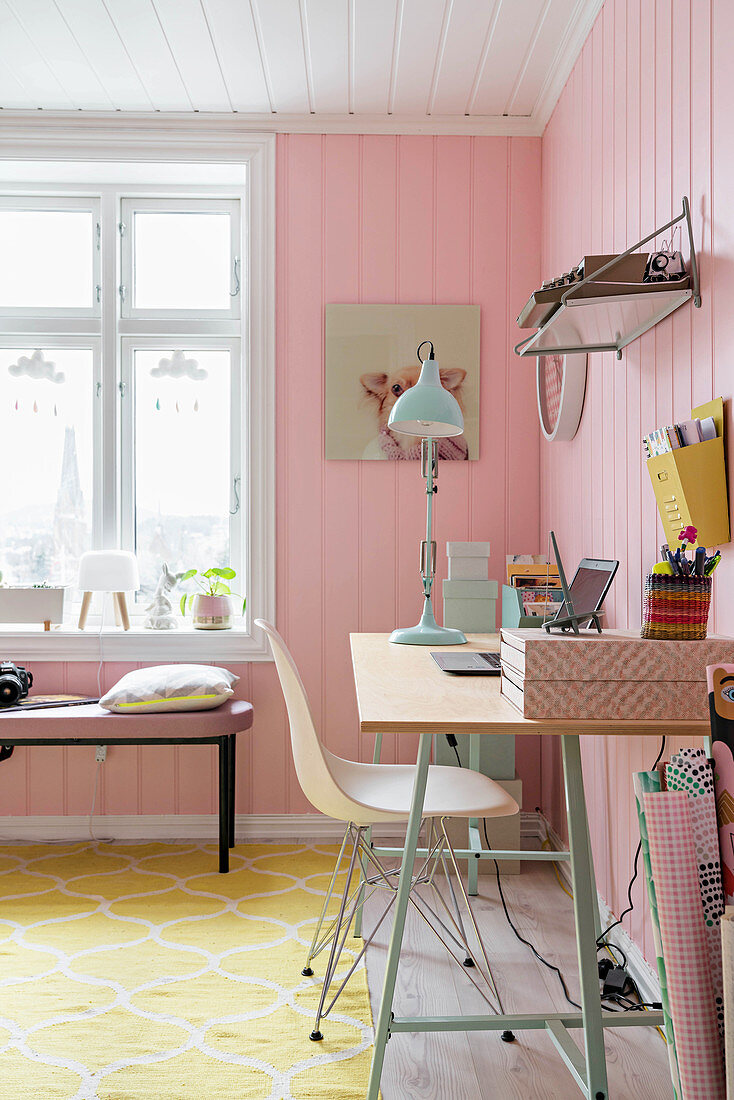 Schreibtisch in femininem Zimmer mit rosa Wänden und gelbem Teppich