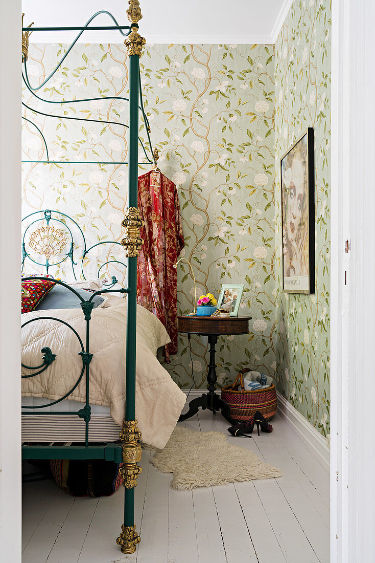 Schlafzimmer im Boho-Stil mit nostalgischem Metallbett und floraler Wandtapete