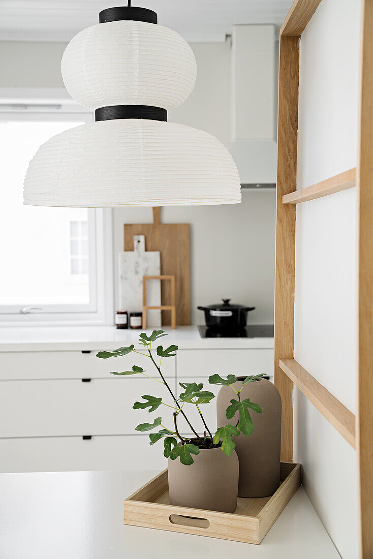 White paper lamp above dining table in white Scandinavian kitchen