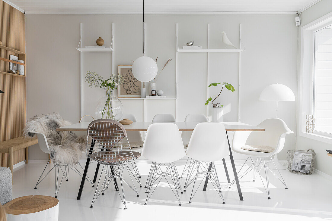 Esstisch mit Eames Chairs in weißem Wohnraum mit Holzelementen