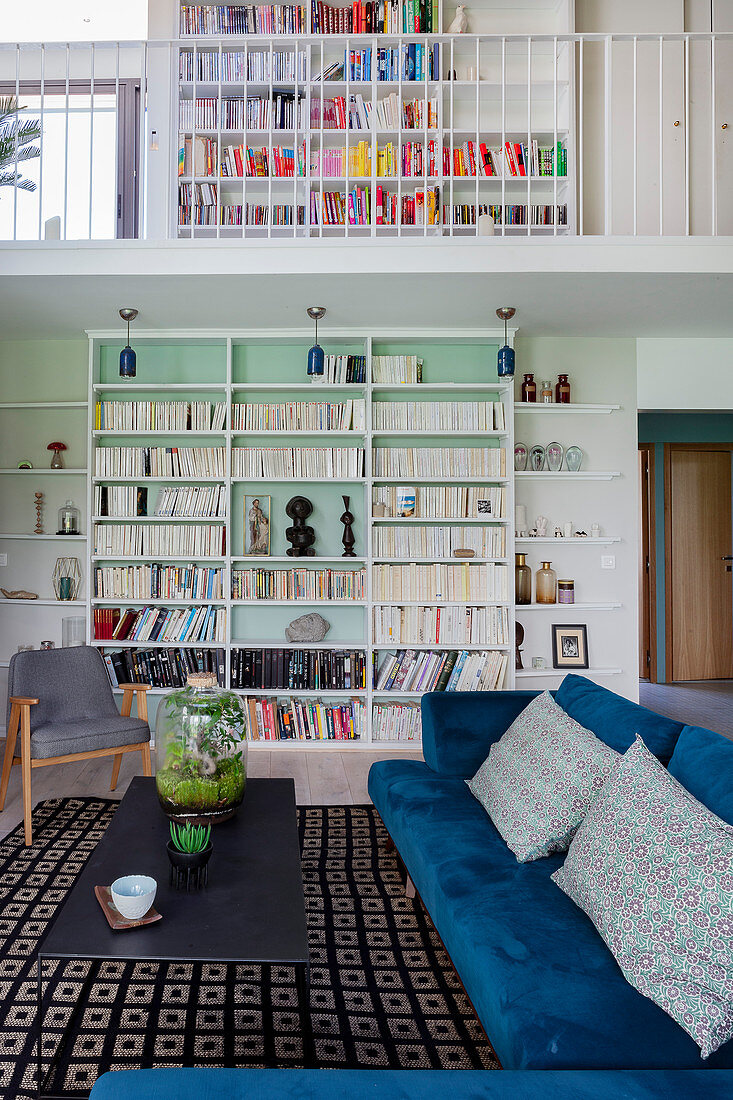 Velvet sofa and bookcase in living area of maisonette apartment