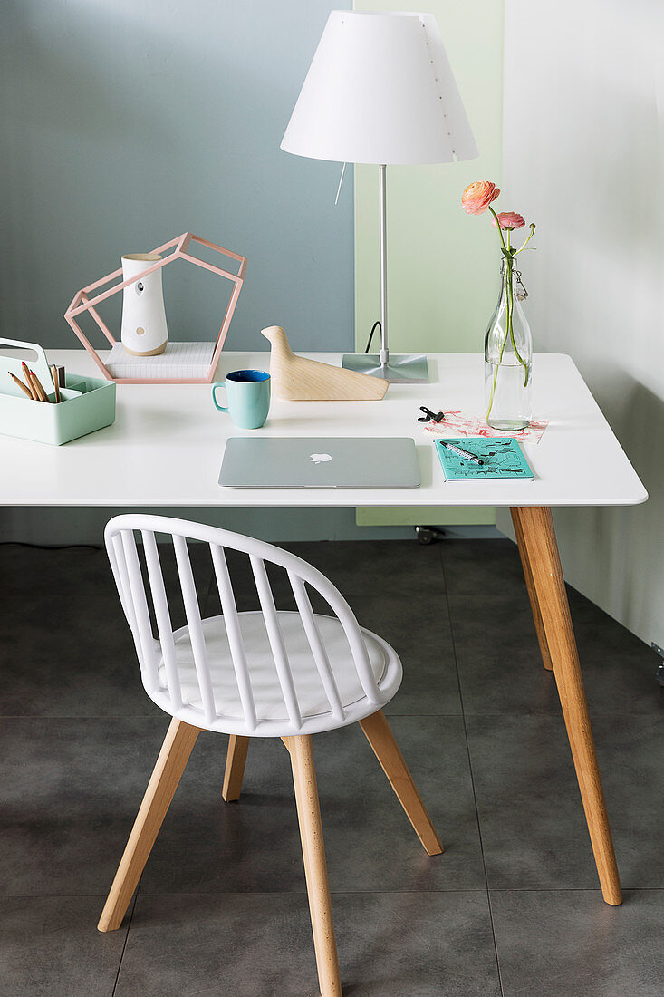 Schreibtisch mit weißer Tischplatte und Holzbeinen in Zimmerecke