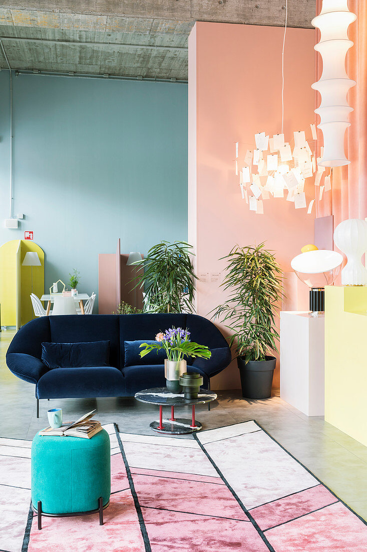 Sitzbereich mit Lampensammlung in Loftwohnung mit pastellfarbenen Wänden und Sichtbetondecke