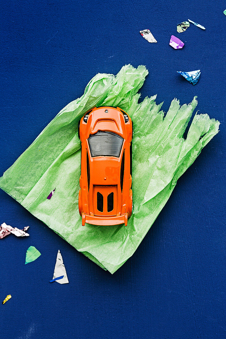Spielzeugauto auf grünem Geschenkpapier