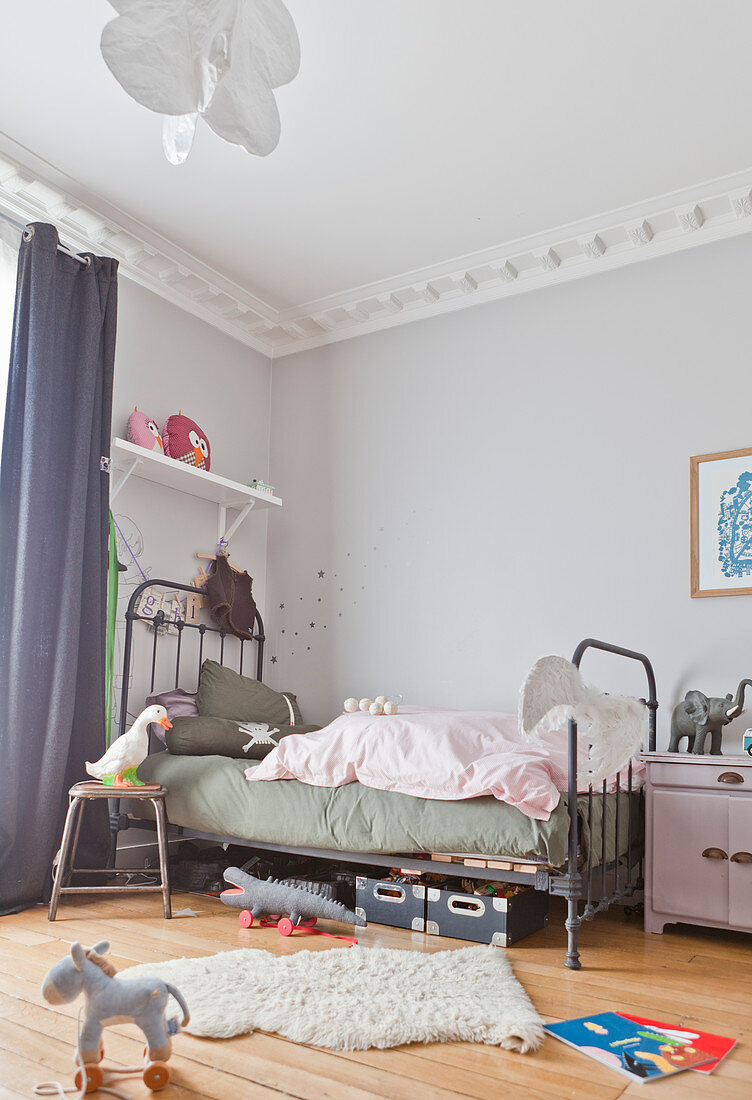 Vintage metal bed in child's bedroom with stucco ceiling frieze