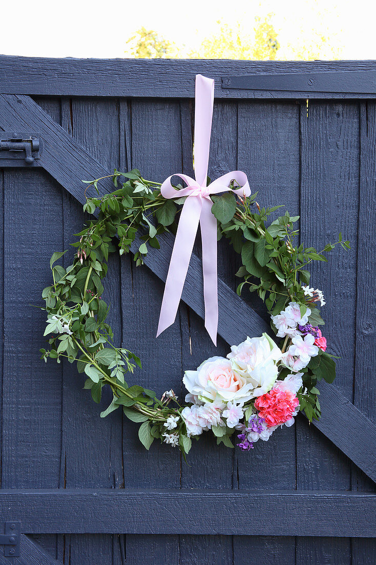 Wreath of leaves and flowers on wooden door