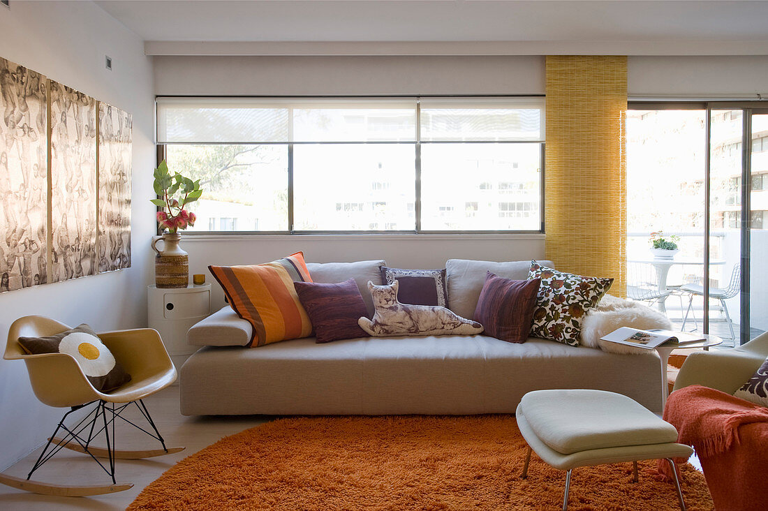 Sofa und Klassikerstuhl im Wohnzimmer mit orangefarbenen Akzenten