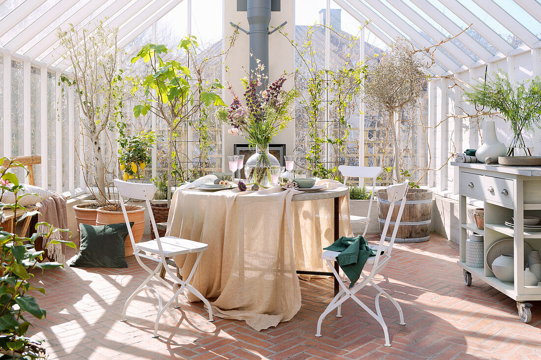 Gedeckter Tisch im sonnigen Gartenhaus