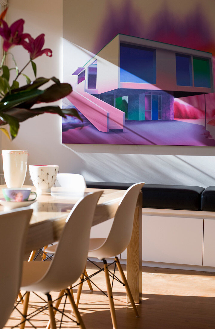 Picture of modern house in shades of purple above dining table in sunlight
