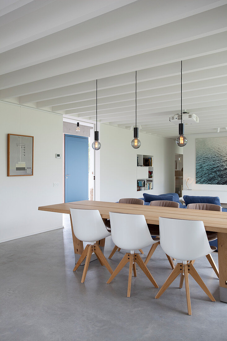 Concrete floor and beamed ceiling in modern, open-plan interior