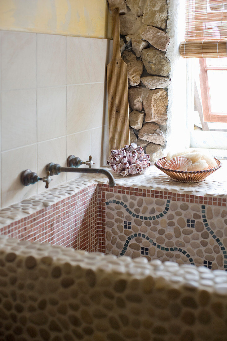 Waschbecken mit Mosaikfliesen und Kieselsteinen
