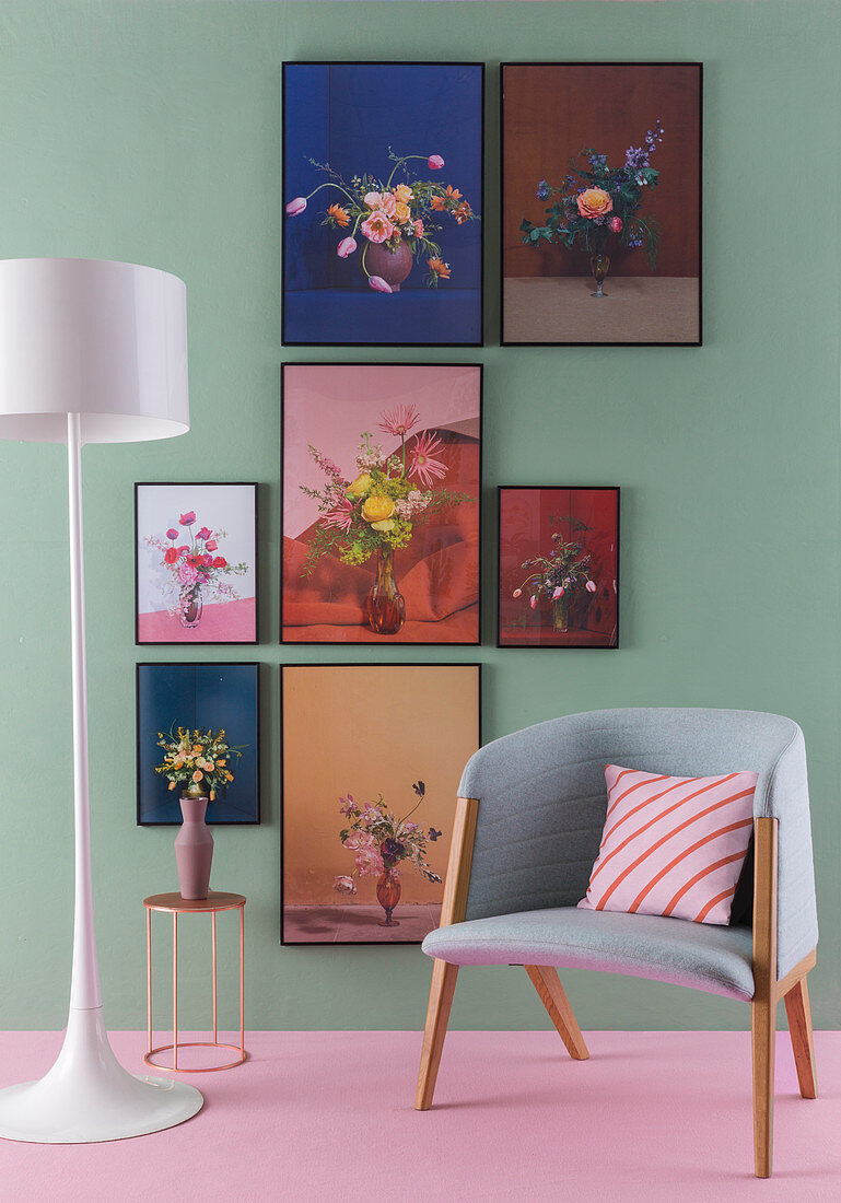 Floral artworks on green wall, standard lamp, side table and armchair