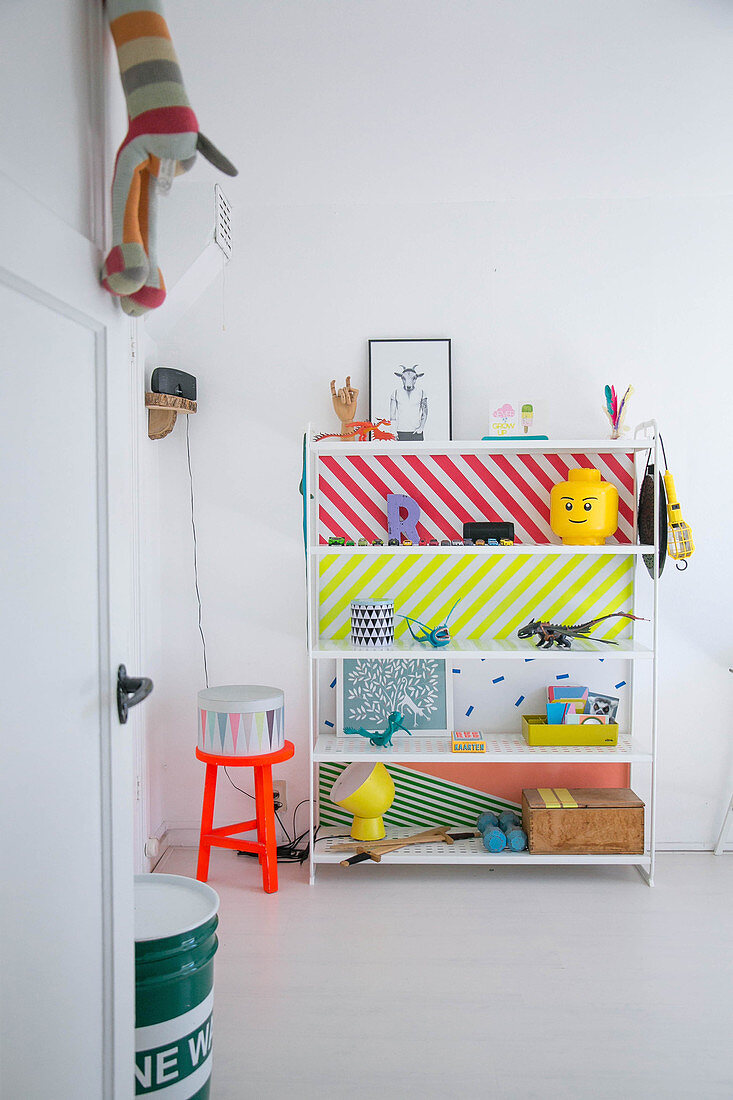 Shelves with brightly coloured back wall in child's bedroom