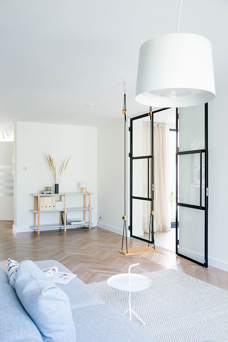 Schaukel und Glas-Stahl-Tür im minimalistischen Wohnzimmer