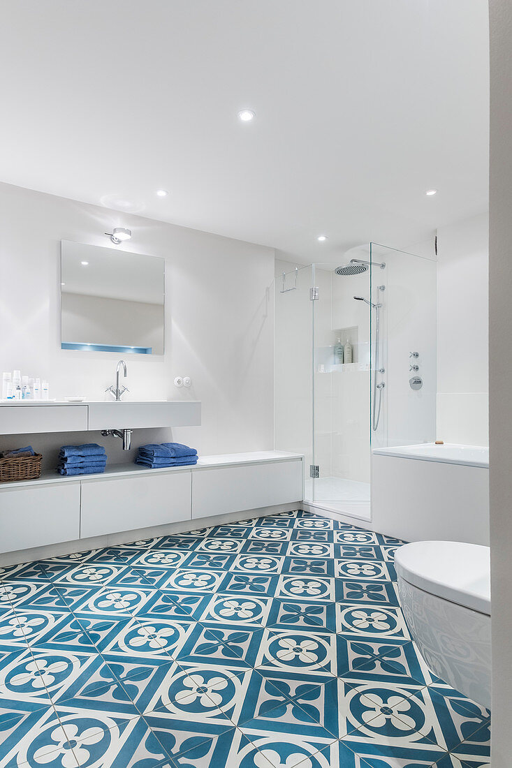 Large, white modern bathroom with blue-patterned floor tiles