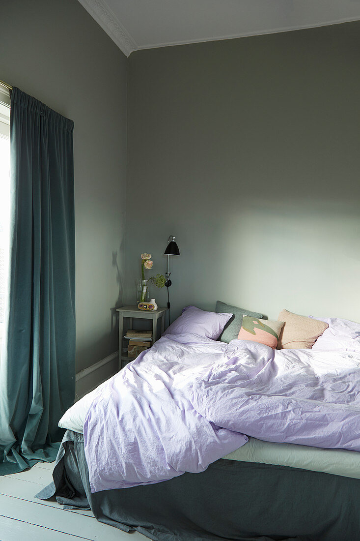 Zerwühltes Bett im Schlafzimmer in Grau