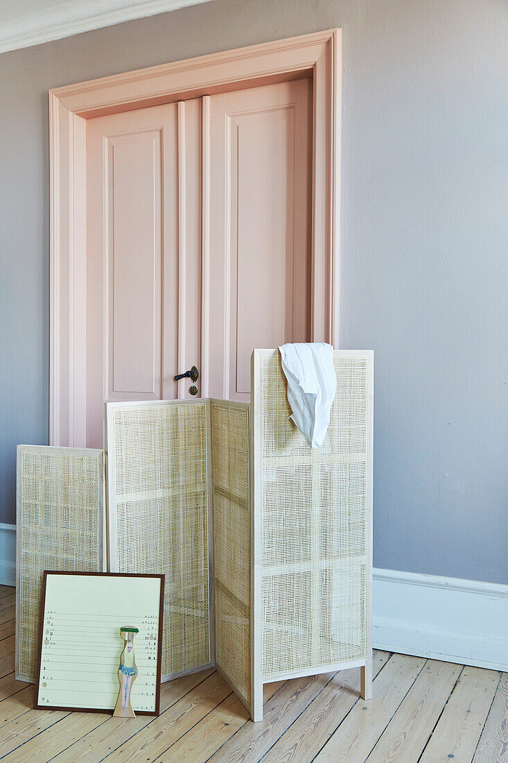 Woven screen in front of pink panelled door