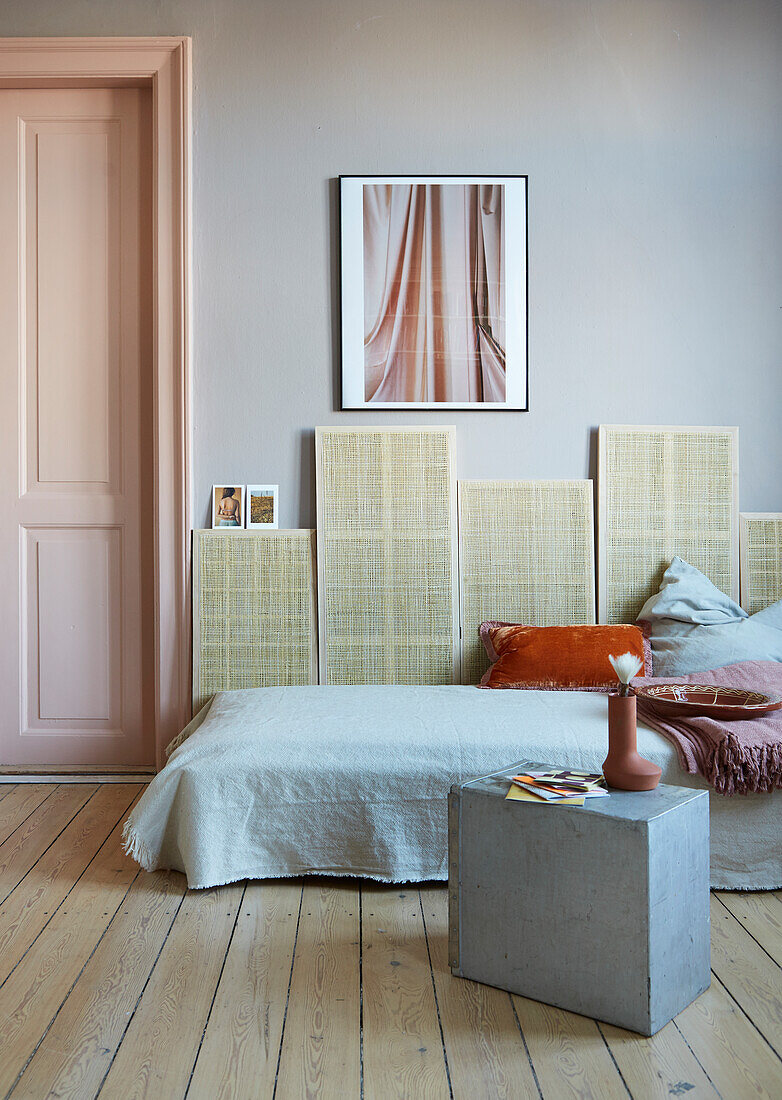 Couch against woven wall panels next to panelled door