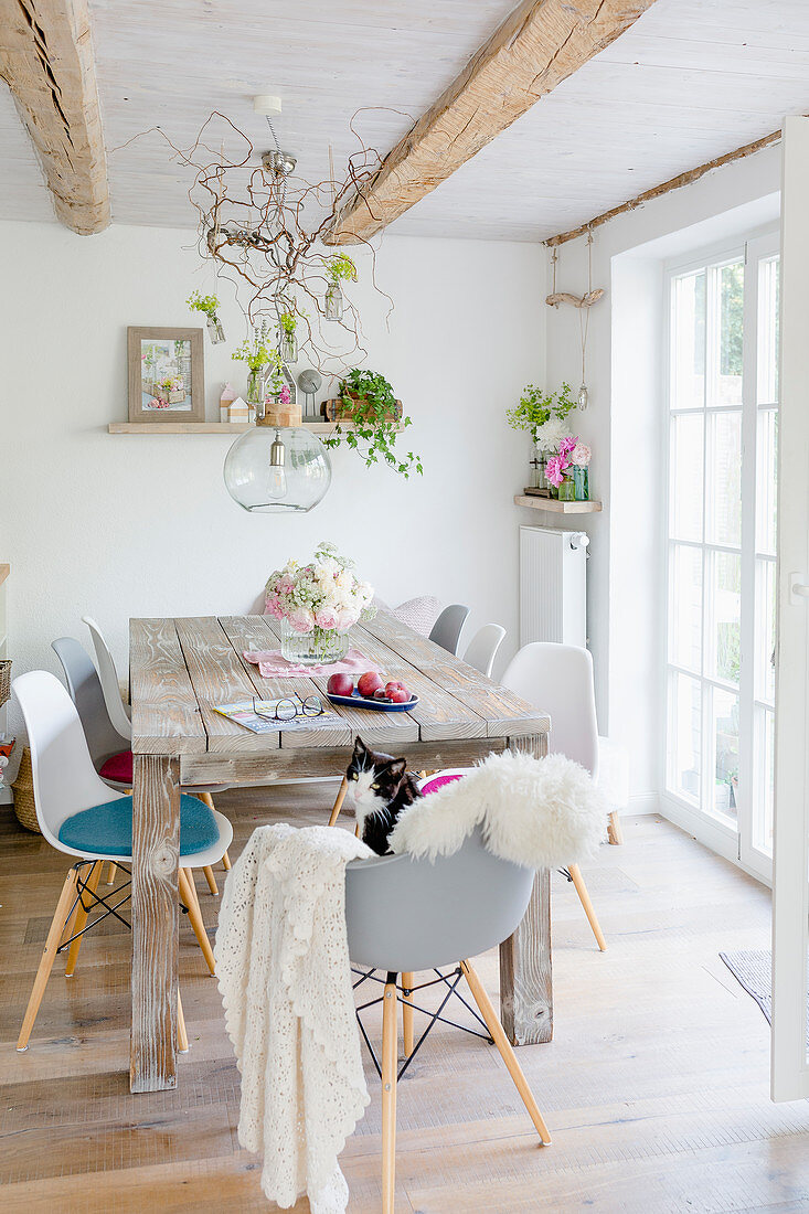 Spring decorations in dining area with wooden table and shell chairs