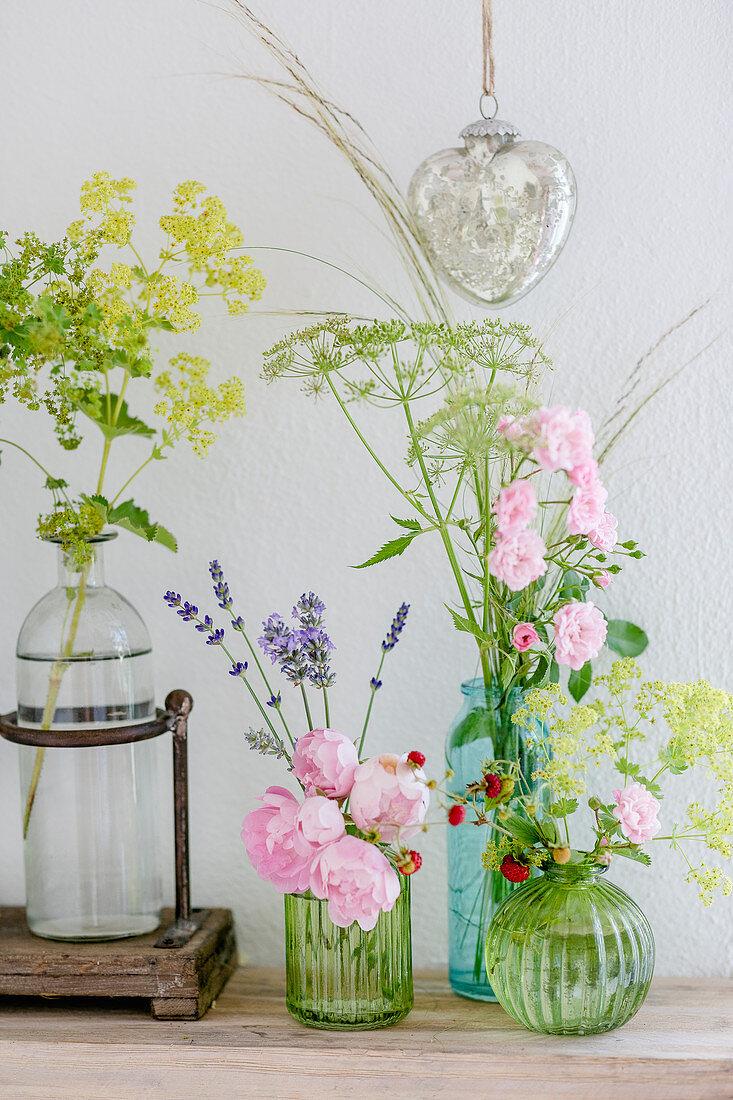Roses, lady's mantle, fennel, lavender and strawberries in glass vases