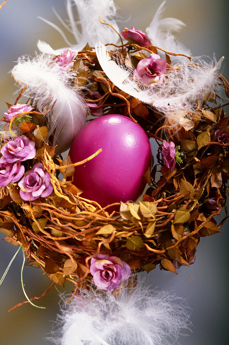 Blühendes Osternest mit rosa Blüten und Federn