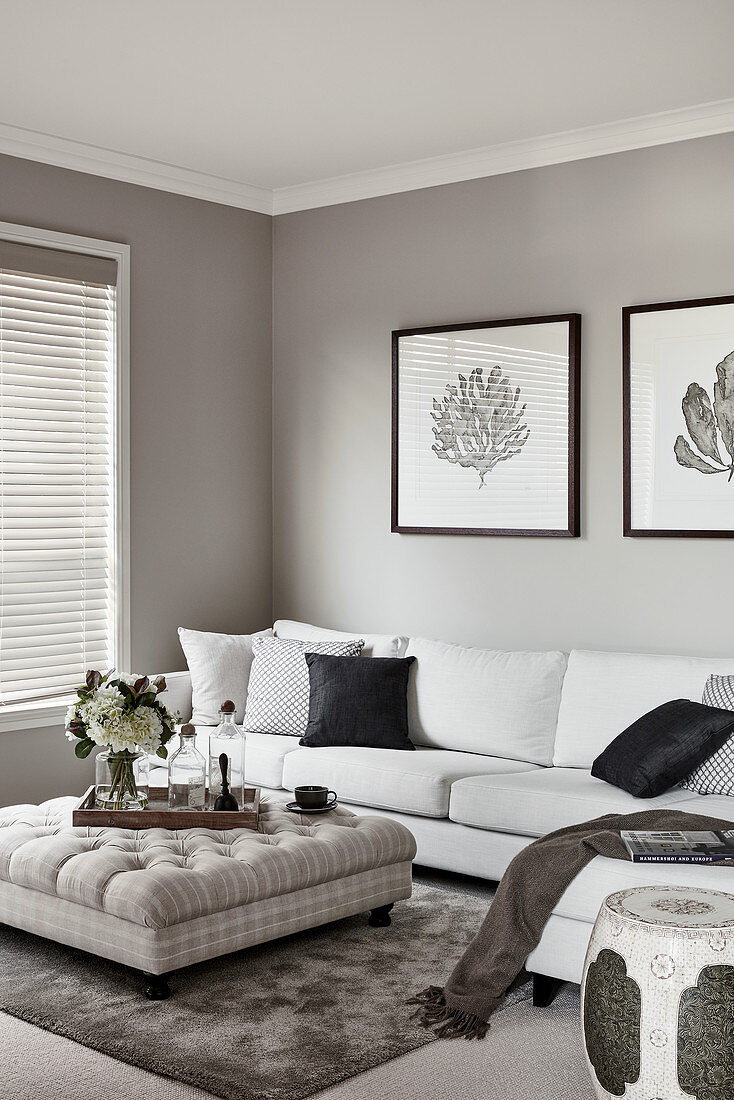 Weiße Couch und Polstertisch im Wohnzimmer