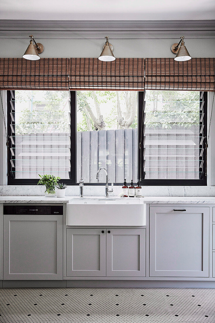 Sink under the louvre window in a classic kitchen in grey