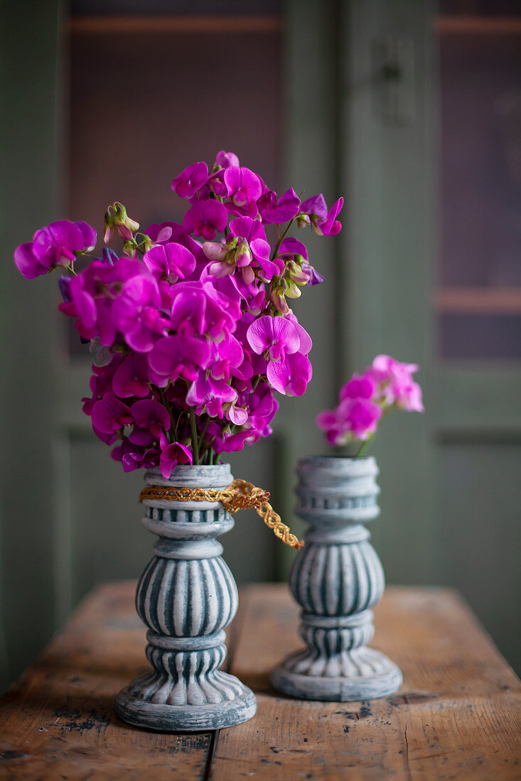 Pink sweet peas in two vases with structured surfaces