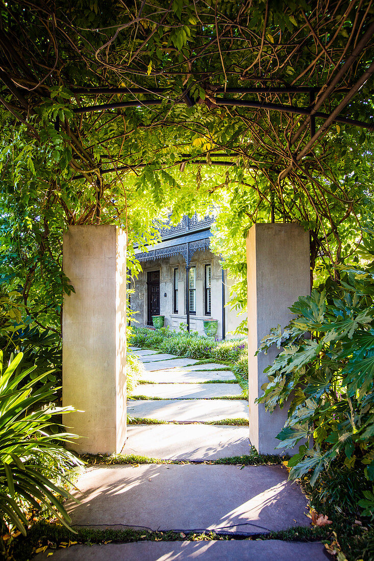 View through overgrown passage to the house with garden