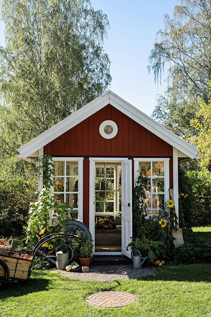 Rotes Gartenhaus im Skandinavischen Stil im Sommergarten