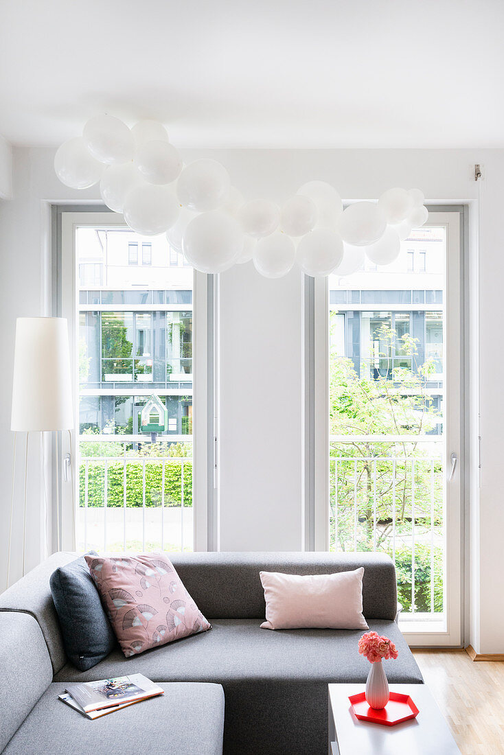 Weiße Luftballonwolke über Sofa im Wohnzimmer