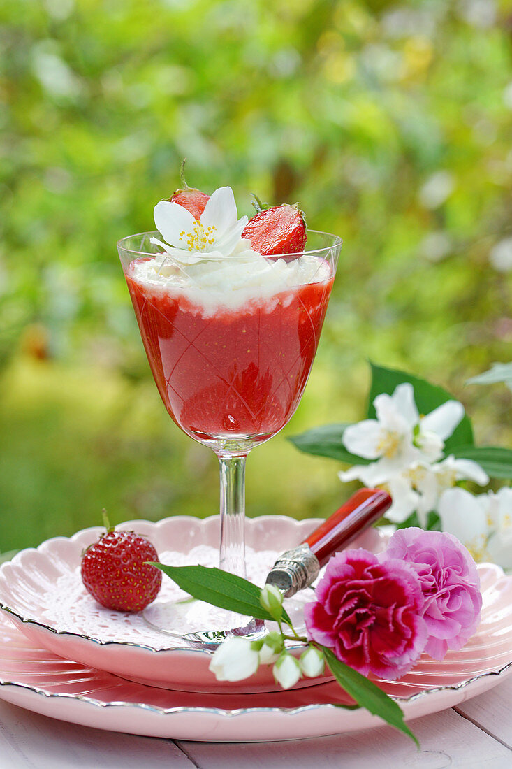 Erdbeermus im Stielglas und Blüten