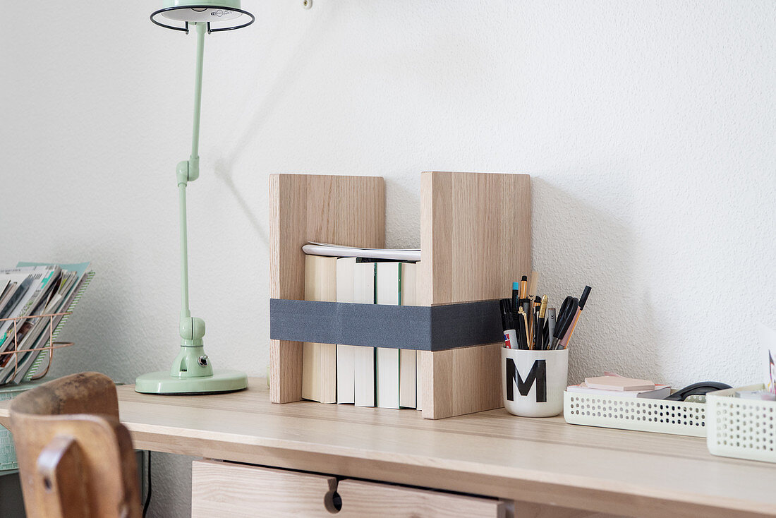 DIY-Buchständer aus hellem Holz auf schmalem Schreibtisch