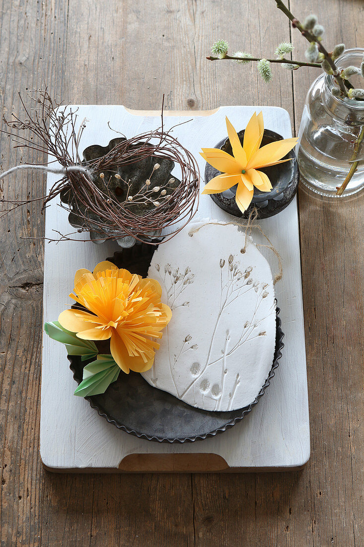 Paper flowers and modelling clay with botanical imprints in flan tin