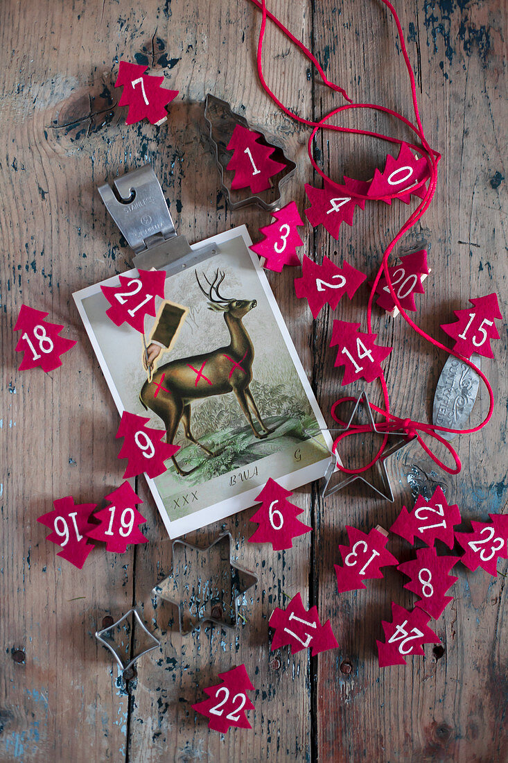 Rote Tannenbäumchen aus Filz mit Zahlen und eine Postkarte mit Hirsch