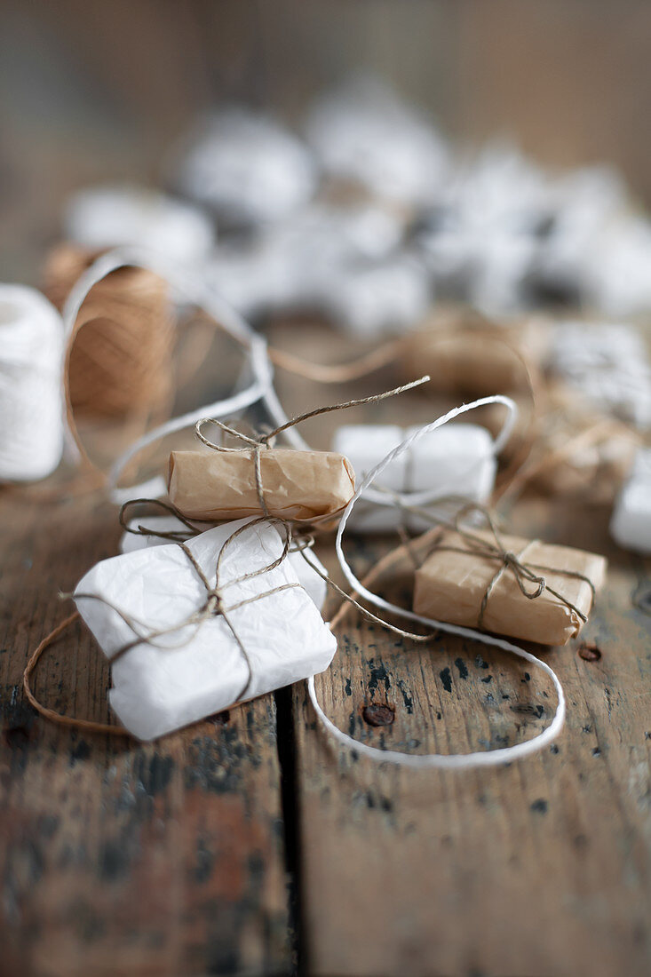 Small gifts wrapped in white and pale brown on wood