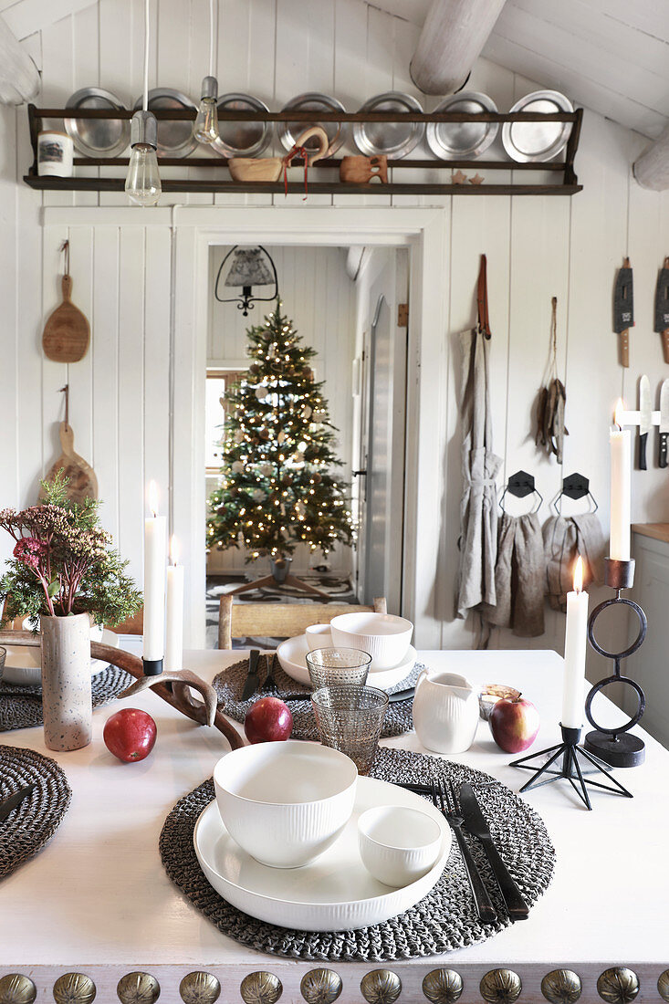 Gedeckter Tisch in rustikaler Küche mit Blick auf den Weihnachtsbaum