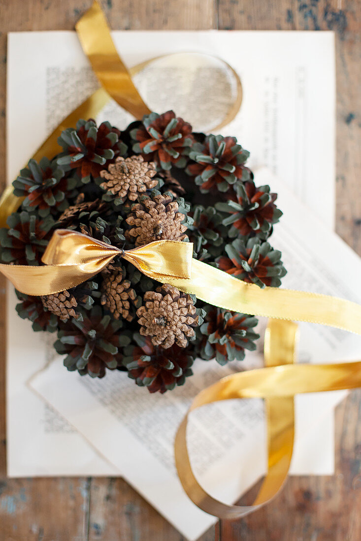 Christmas arrangement of pine cones and gold ribbon