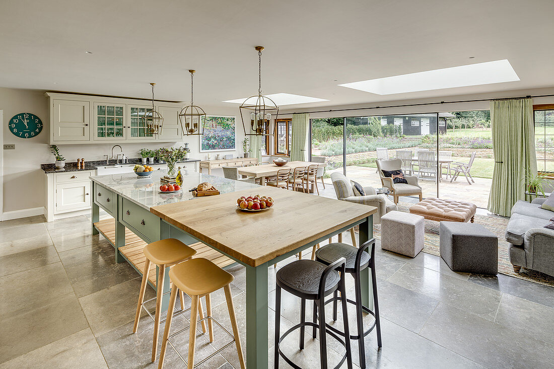 Country-house kitchen and seating area below skylights and glass sliding doors leading to terrace