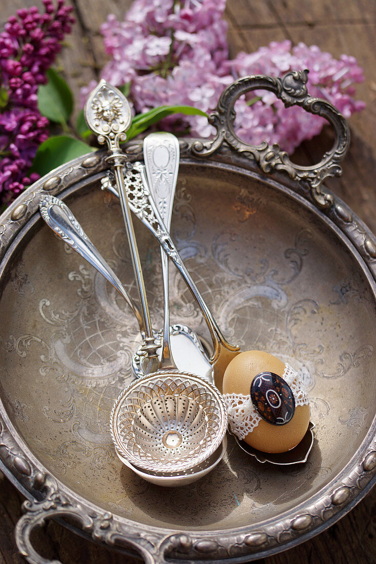 Egg with tip on antique silver spoon in silver bowl