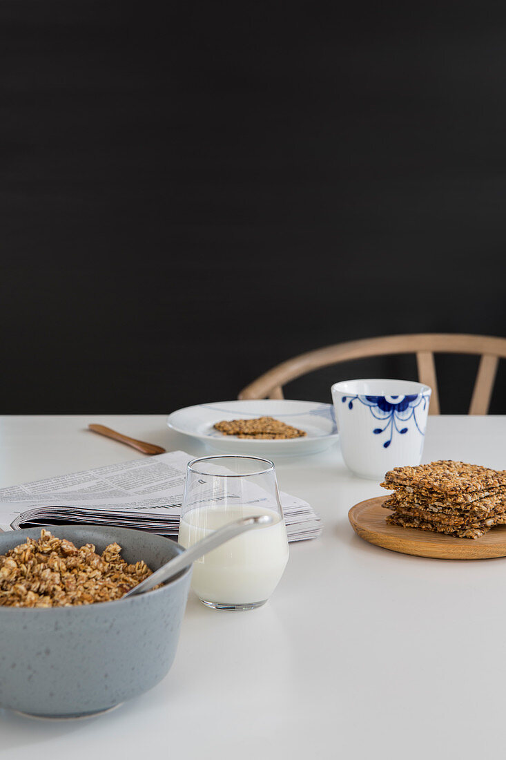 Simple, classic breakfast of muesli, milk and newspaper