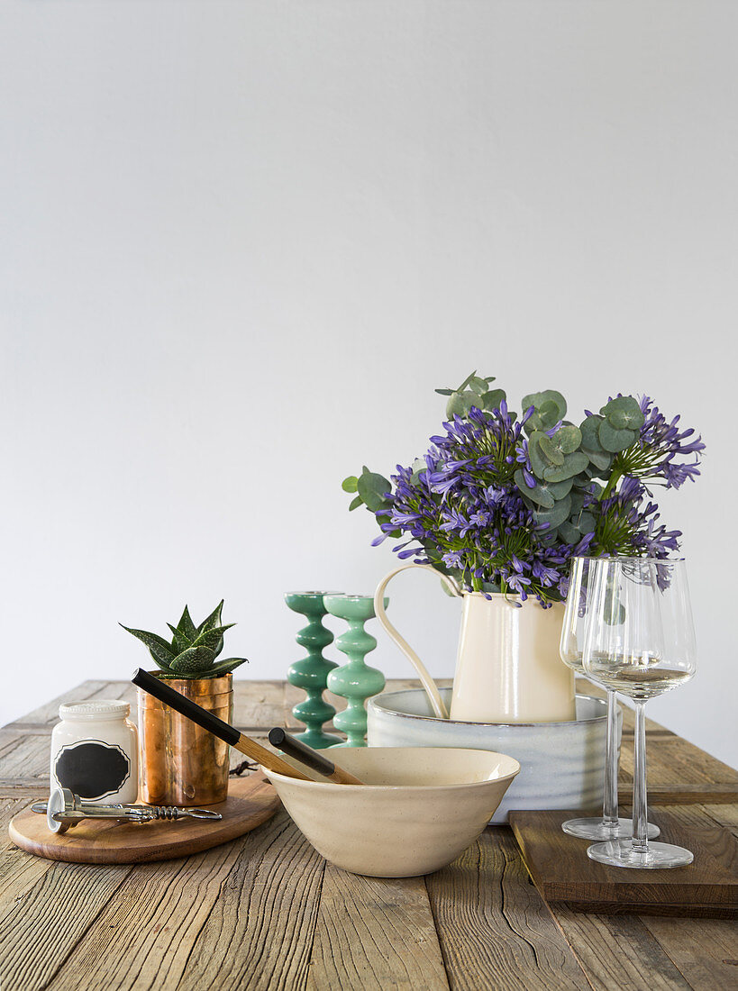 Schlichte Küchenutensilien und Blumenstrauß auf dem Holztisch
