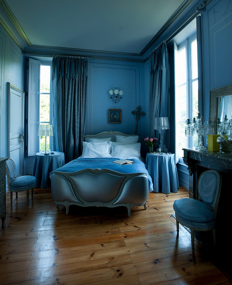 Blaues Schlafzimmer mit Antikmöbeln und Kamin
