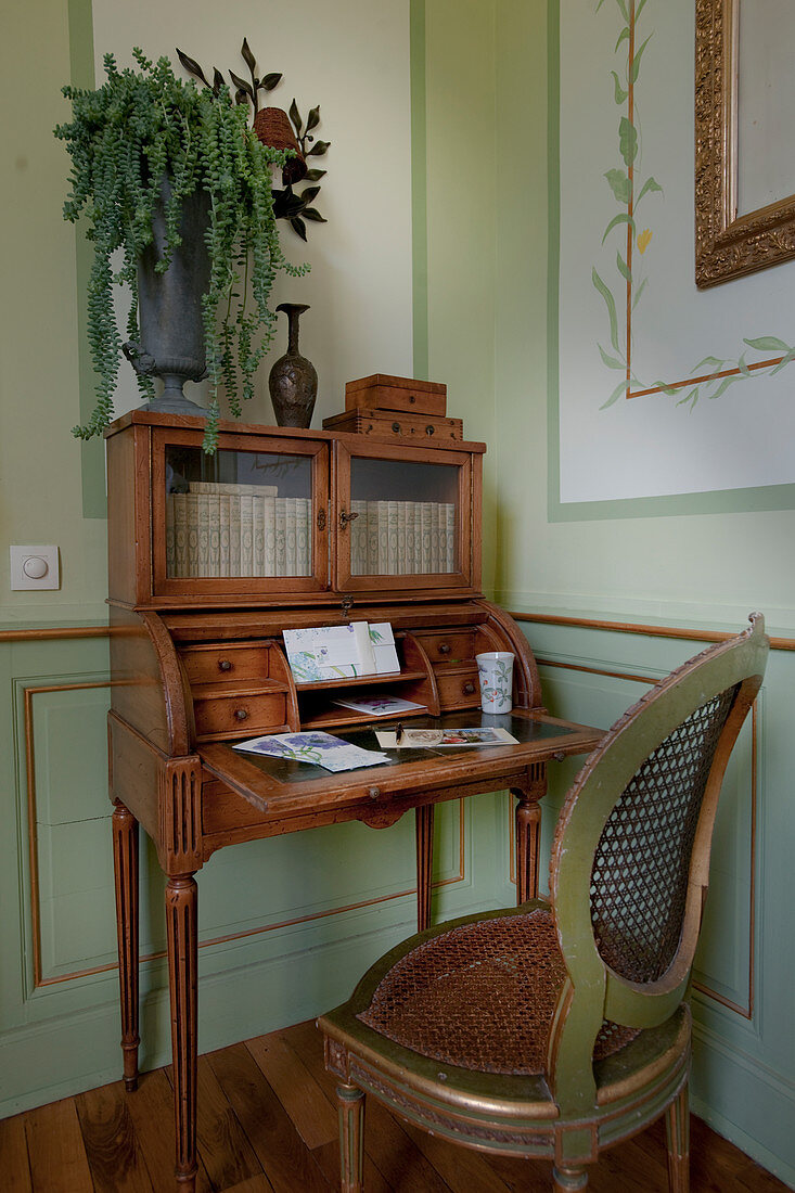 Cane chair at antique writing desk with glass doors